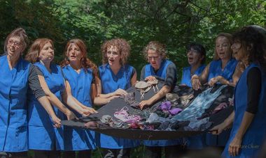 LES FILLES DU RAMDAM : GROS BONNETS ET SOUTIFS Malgré quelques défauts que l’amateurisme excusera sans mal, on dira beaucoup de bien de ces Filles du Ramdam (« chœur de femmes sauvages et sensibles autour de chants du monde et de créations personnelles ») dans leur spectacle « Entre deux voix ». Treize femmes sur scènes pour une fable qui n’en est guère, tant elle se duplique sans faire le une de l’actu. Elles sont ouvrières dans le sous-vêtements, petites mains rodées dans l’art du soutif et de la petite culotte. Marionnettes dont se jouent des actionnaires dont la cupidité n’a d’égal que le cynisme. Et elles, dans le marigot des promesses et de la fausse compassion, dans la jungle des législations et des banques, de tenter de s’en sortir la tête haute, de sauver leur boulot, de pouvoir continuer à payer leur bouffe et leur loyer. Rien que de mettre ça en scène est preuve de grand courage. On doit la mise en scène à Juliette Z, que la Chansonnade avait déjà fait venir il y a peu, artiste du cru, étonnante de créativité et d’audaces. Là, chaque actrice-ouvrière a tissé un peu du canevas de cette presque comédie musicale, en apportant un peu beaucoup d’elle, en y ajoutant son ou ses chants. Ça chante, ça déchante, ça enchante, qui plus est en plusieurs langues. C’est efficace et beau. La fable, on s’en doute, est cruelle : dans le domaine du soutien-gorge on ne lutte pas contre les gros bonnets. Mais la lutte, la tentative de lutte, c’est déjà s’ouvrir aux autres, réfléchir, porter un regard sur ce qu’on est, ce qu’on veut. Le pourquoi, le comment. C’est enfoncer un coin dans la machine, qui plus jamais ne fonctionnera pareillement. Guettez ces Filles du Ramdam si, par chance, elles passent près de chez vous. Elles ont de la force et de la gouaille à revendre : par les temps qui courent, c’est rien que du bonheur. (photo Marie Olivier)